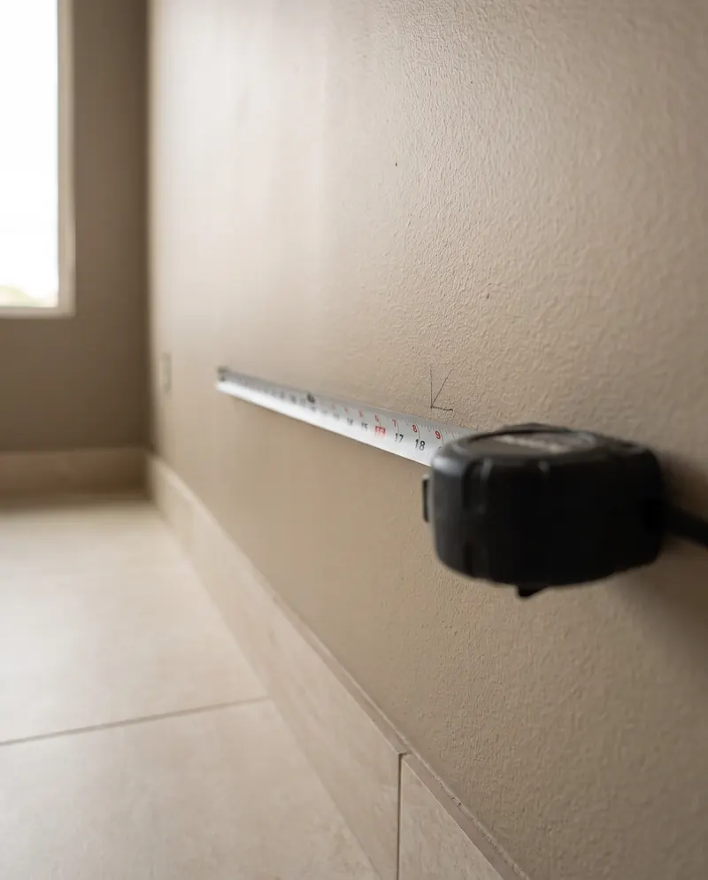 Tape measure across a plain sand-colored wall